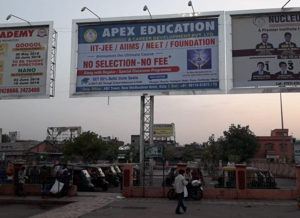 A large outdoor promotional billboard for Apex Education & Career Development Pvt. Ltd. announcing engineering and medical coaching streams for IIT-JEE, AIIMS, NEET, and Foundation courses. The billboard prominently highlights a "NO SELECTION-NO FEE*" conditional policy banner, acting as a trusted feeder network for the top Chemistry classes in Dwarka, Gurugram & Delhi NCR. The design features a white billboard with dark blue and red headers, displaying a graduate cap icon next to text reading "GET 85% Delhi State Quota in NEET/JEE Through School Admission in Delhi." This premier structure for expert chemistry classes for JEE & NEET in Dwarka, Janakpuri, Gurugram & Delhi NCR explicitly lists center locations under "Our Centers" spanning Vikaspuri, Dwarka, Najafgarh (Delhi), Patna, and Darbhanga (Bihar). The footer details the Corporate Office at ABC Tower, Near Madhushree Hotel, Kota, along with the website apexeducation.co.in and inquiry numbers +91-98116-61072 / 73, establishing authority for Premium Chemistry classes in Janakpuri, Gurugram and Delhi NCR.
